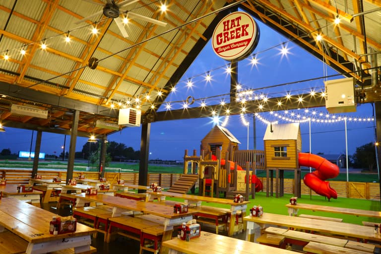 covered patio bar area with string lights overlooking the kids jungle gym